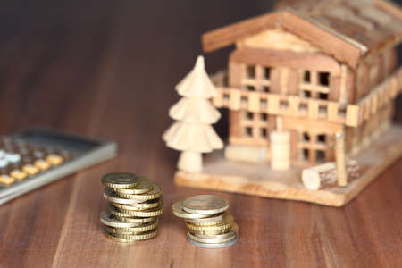 money coins with house model and calculator in backgroundの写真素材