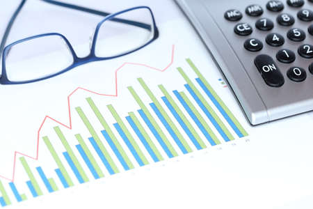 diagram with calculator and glasses on a workplaceの写真素材