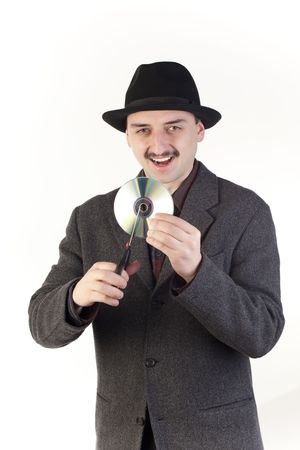 Man in hat cutting a compact discの写真素材