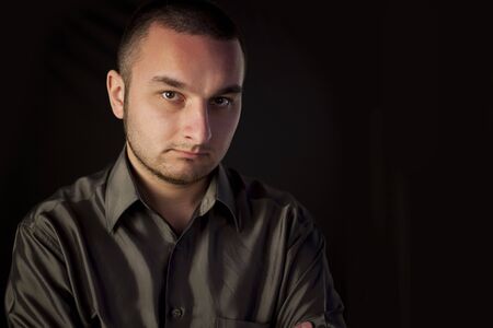 Serious young man looking at cameraの写真素材