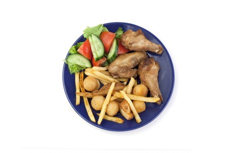 Vegetables, chicken wings, French fries in a plateの写真素材