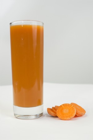 Glass of  juice with carrot pieces の写真素材