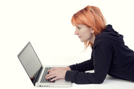 Girl typing and looking at screen of laptopの写真素材