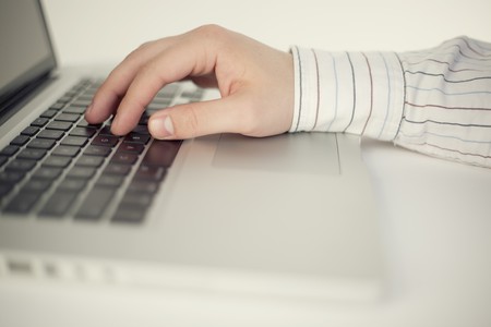 Isolated on white laptop with a human handの写真素材