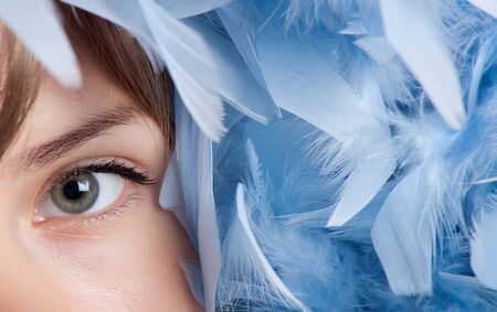 Girl posing with blue feathersの写真素材