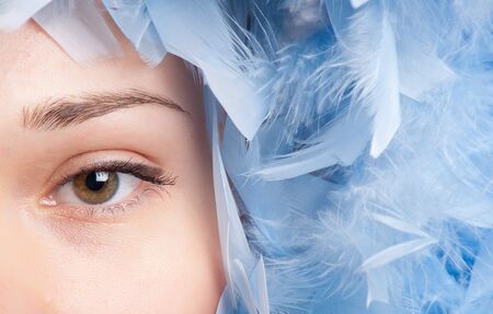 Girl posing with blue feathersの写真素材