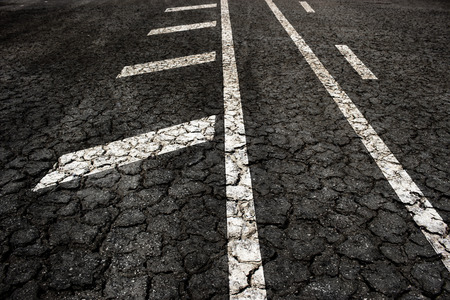 Crack asphalt road on arrow background.の写真素材