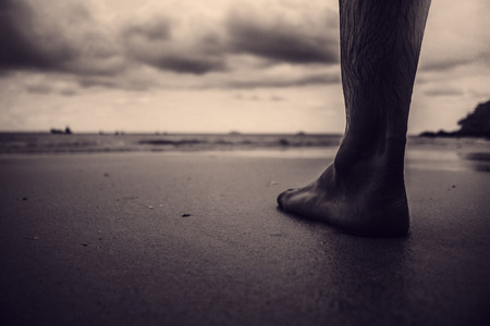 Foot man standing closeup black and white background.の写真素材