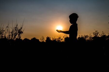 Children catch the sun silhouette.の写真素材