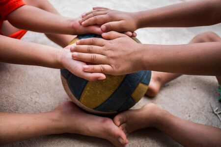 Children hold hand play football create friendship concept.の写真素材