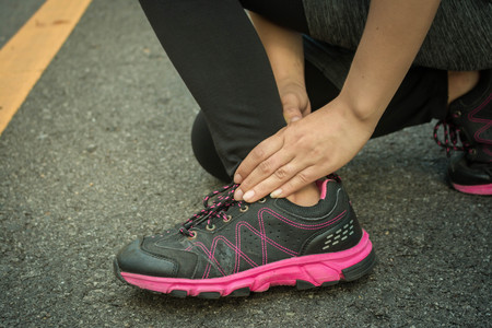 Young women accident ankle sprained over from running.の写真素材