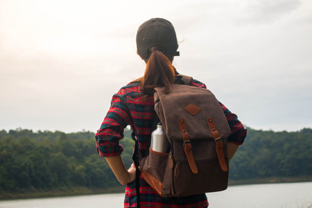 Woman with backpack walking in the mountains by the riv.の写真素材