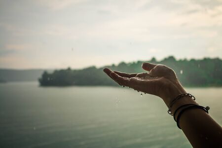 The hands of a girl who is playing rain.の写真素材