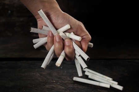 Hands clenched the cigarette tight. Concept stop smoking.の写真素材