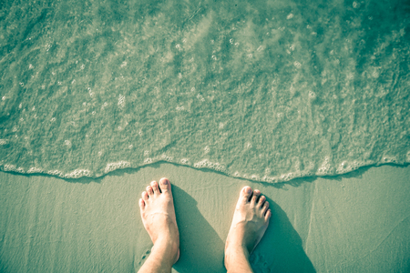 Foot on the white sand.