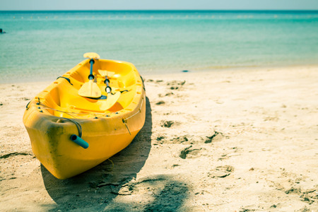 Yellow boat parked on the sand.