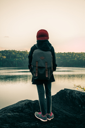 Women with backpack by the the riverside.