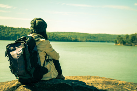 Women tourists with backpack sitting on the river.の写真素材