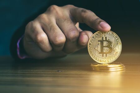 Hand of a businessman holding a coin of bitcoin.の写真素材