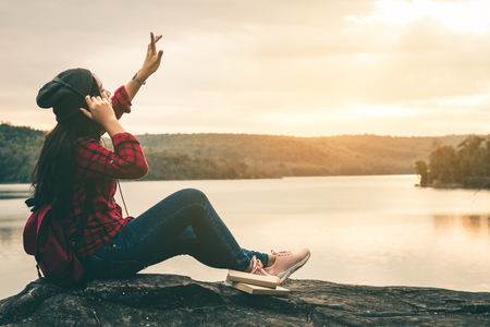 Female travelers listen to beautiful natural music with a quiet scene on holiday.の写真素材