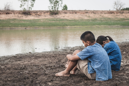 Children and water on arid soil in hot weather lacked drinking water.の写真素材