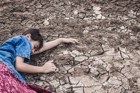 The women on the arid soil in hot weather lacked drinking water.の写真素材