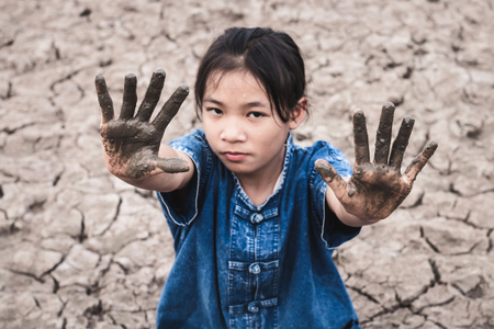 The women on the arid soil in hot weather lacked drinking water.の写真素材