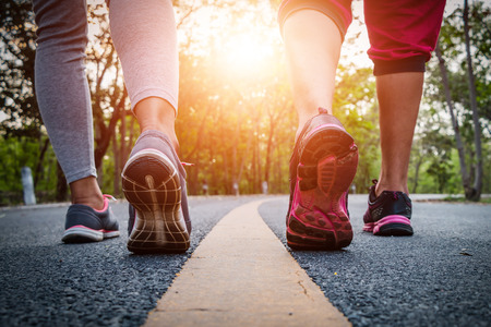 Women and men runner feet on road in workout wellness concept.の写真素材