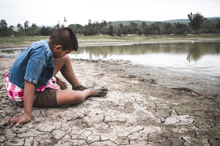 Men on ground cracked dry due to drought, food shortages and water,  Concept drought and crisis environment.の写真素材