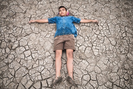 Men on ground cracked dry due to drought, food shortages and water,  Concept drought and crisis environment.の写真素材