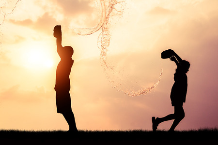 Children playing splash water on Songkran silhouette.の写真素材