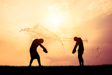 Children playing splash water on Songkran silhouette.の写真素材