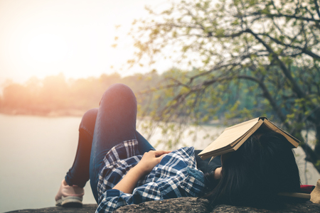 Women tourists read books in quiet nature.の写真素材