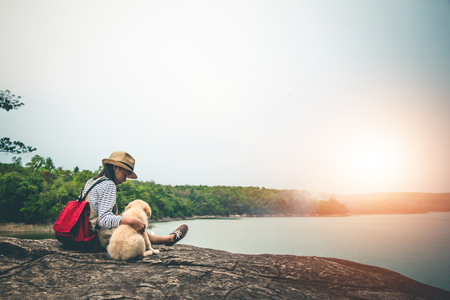 Female tourists and beloved dogs in beautiful nature in a tranquil setting.の写真素材