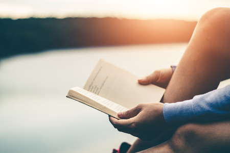 Women tourists read books in quiet nature.の写真素材