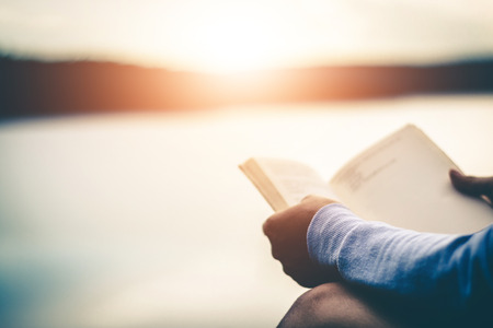 Women tourists read books in quiet nature.の写真素材