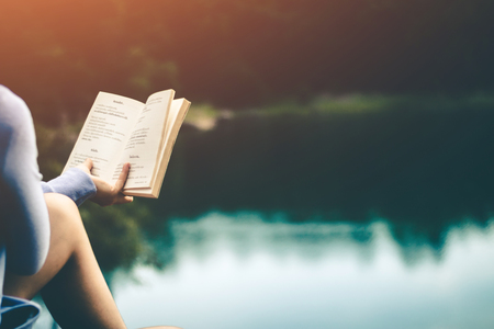 Women tourists read books in quiet nature.の写真素材