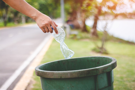 The hand of a woman who is dumping garbage in the trash.の写真素材