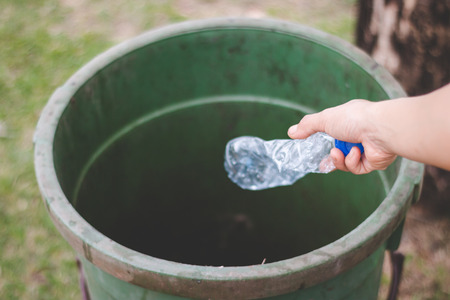 The hand of a woman who is dumping garbage in the trash.の写真素材