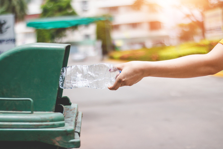 The hand of a woman who is dumping garbage in the trash.の写真素材