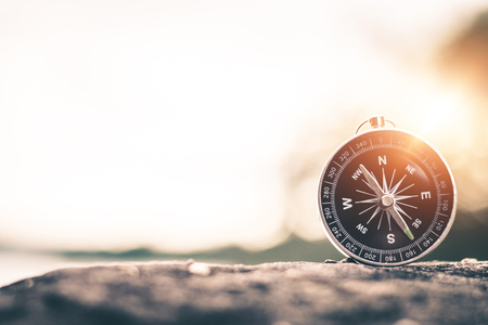 Compass of tourists on mountain at sunset sky.の写真素材