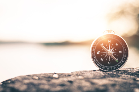 Compass of tourists on mountain at sunset sky.の写真素材