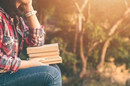 Women tourists read book in quiet nature.の写真素材