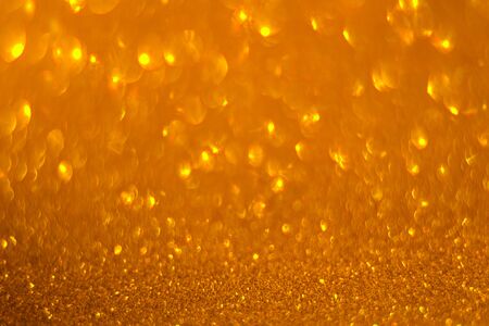 Gold shining lights sparkling glittering blurred background.の写真素材