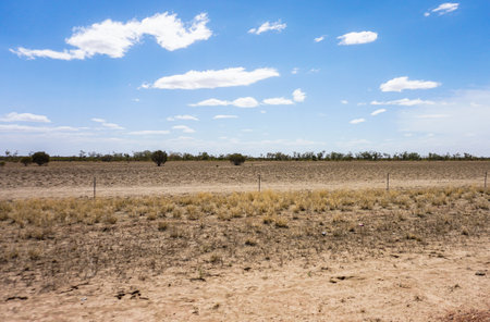 The Expansive Landscape of Dry Desert Terrain is Set Under a Clear and Sunny Skyの写真素材