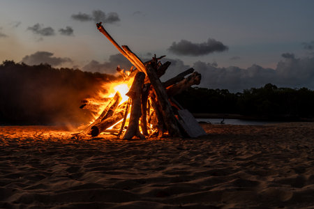 A large bonfire on the beach at sunsetの写真素材