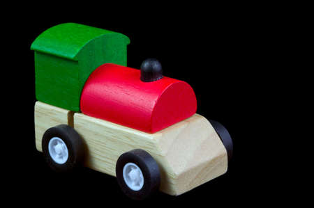 A childs wooden train isolated on a black backgroundの写真素材