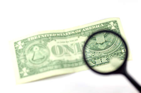 View through a magnifying glass the back of a one dollar note, isolated on whiteの写真素材