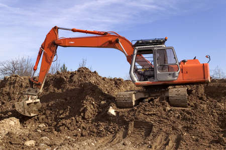 Construction digger on a mound of earth