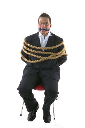 Businessman tied up with rope and gagged with his own tie.の写真素材